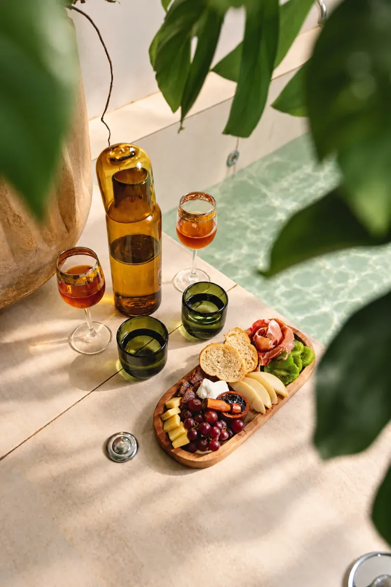 Bebidas y tabla de quesos junto a una tina
